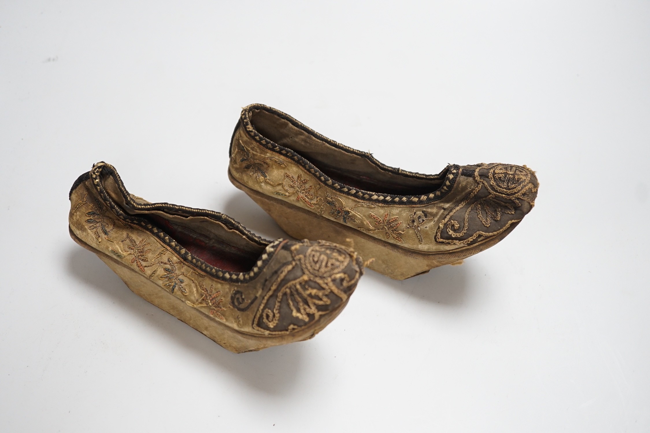 A pair of late 19th century Chinese silk embroidered shoes with Bell inset soles